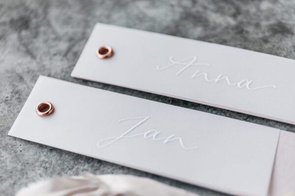 kalligrafierte Platzkarte und Anhänger für Gastgeschenke, kupferfarbene Öse