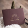 Briefumschlag für einen Adventskalender für vier Adventssonntage, es ist ein geprägter Schwibbogen mit einer angezündeten Kerze zu sehen und darunter die Worte erster Advent, die Prägung ist Gold.